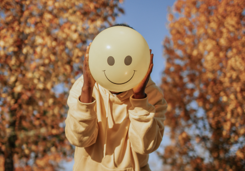 person with smiley face balloon